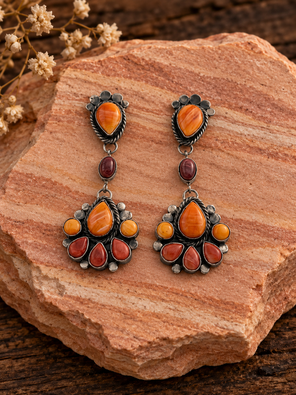 Orange and burgundy multistone dangle earrings on rose sandstone