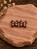 Red and iridescent butterfly earrings on rose sandstone