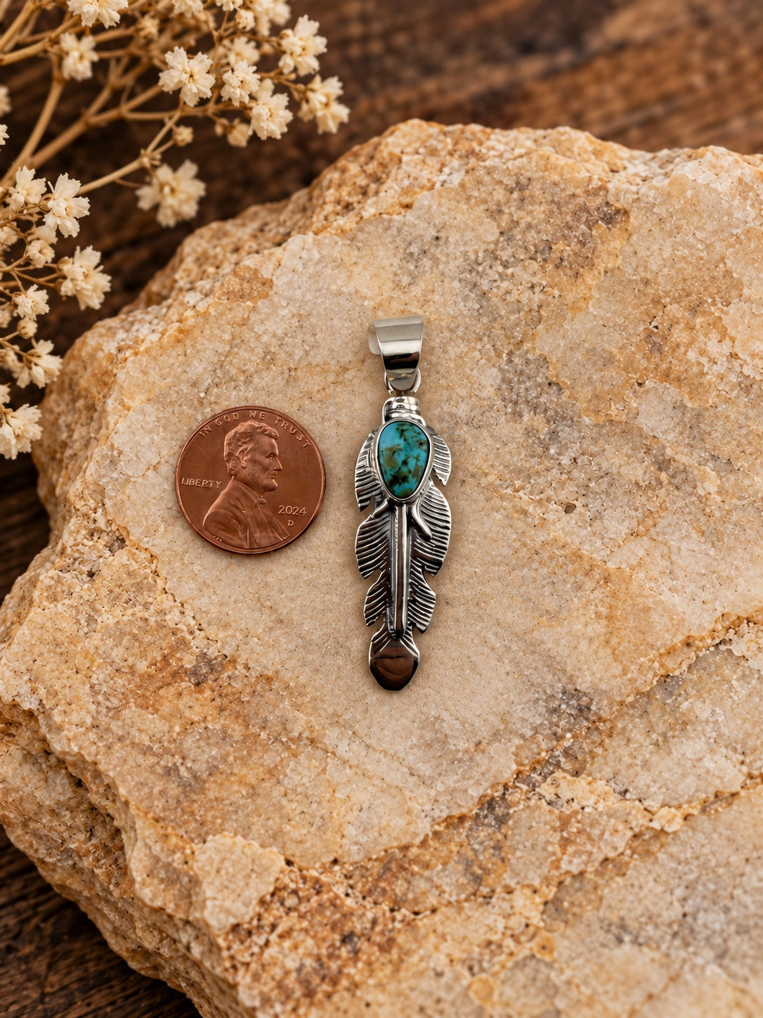 Turquoise Feather Sterling Silver Pendant shown beside a penny for scale